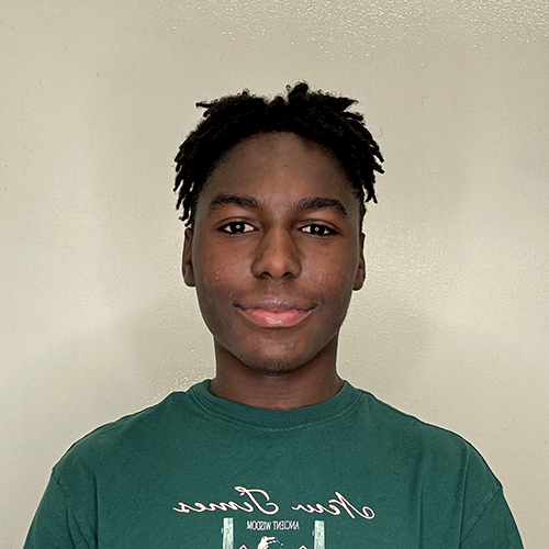 A smiling Black teenager with short hair wearing a green t-shirt.