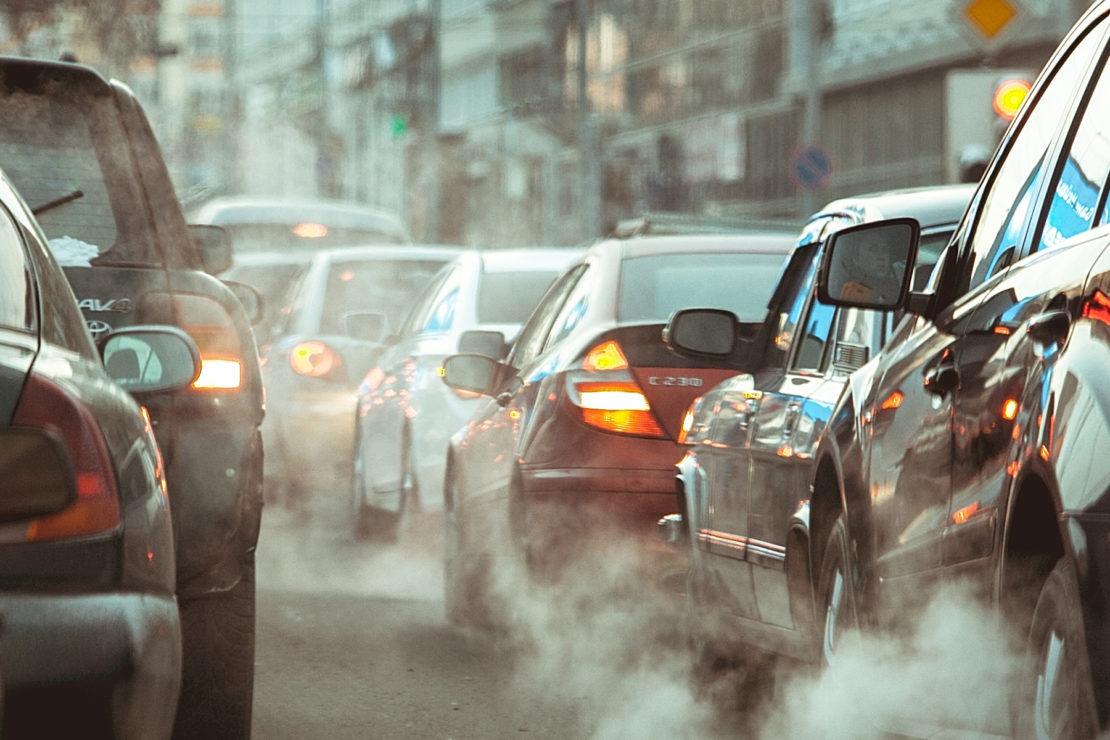 two lines of traffic with visible air pollution emitting from tailpipes
