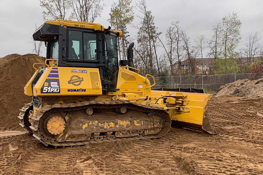 Yellow and black bulldozer pushing soil across