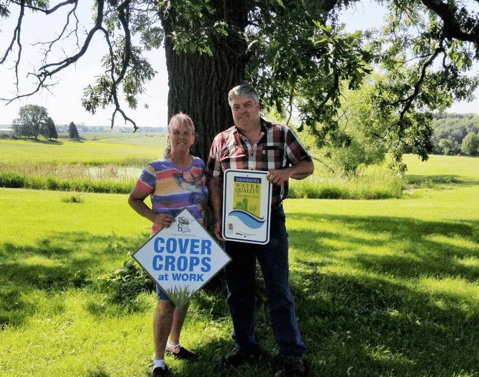 Mike and Kay Peterson standing in front of a tree on a sunny day